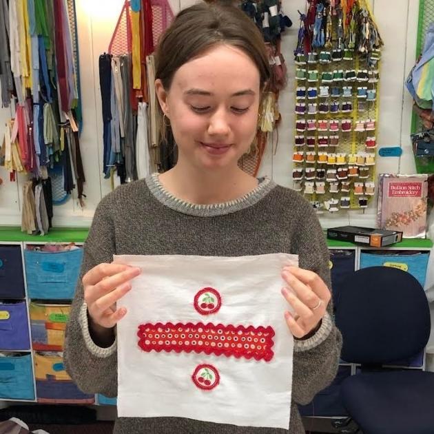Quilt Project contributor Willa Davis looks over the square she created during a project session...