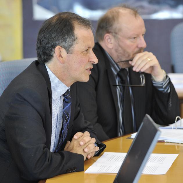 Len Andersen, in typical pose, focuses as then Port Otago chief executive Geoff Plunket (left)...