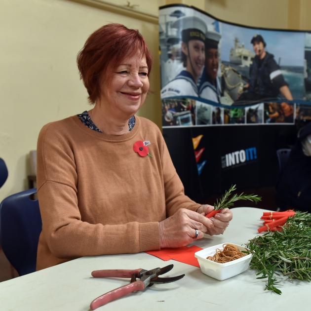 Volunteer Evelyn McDowall makes posies for Anzac Day, at HMNZS Toroa in Dunedin, yesterday. PHOTO...