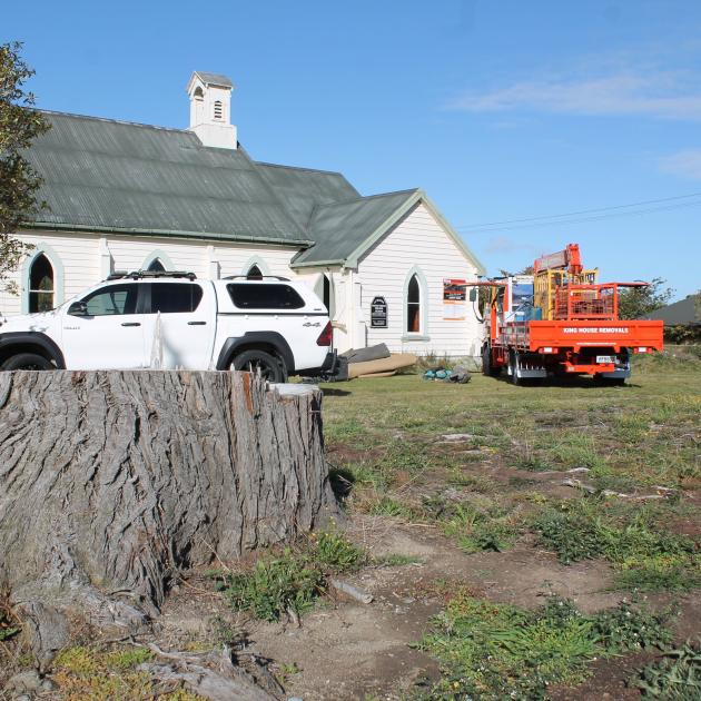 A tree stump remains on the grounds outside Lumsden Presbyterian Church. Work began for the...