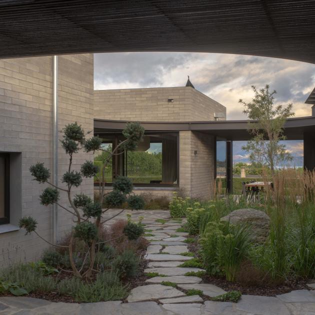 A casual meander over stone pavers links a sequence of gardens to a spacious central courtyard at...