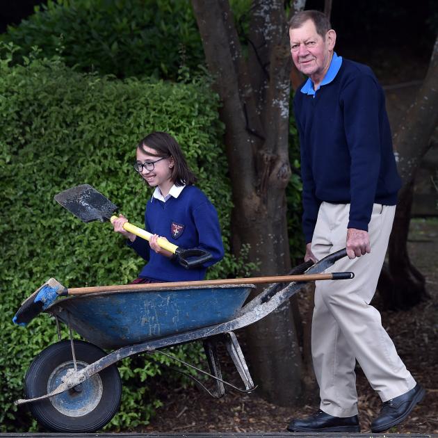 Retiring Sacred Heart School caretaker Ken Pearson pushes pupil Lucie Harfoot, 10. Mr Pearson has...