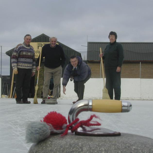 Then Otago MP David Parker sends a curling stone down the Maniototo Ice Rink watched by (from...