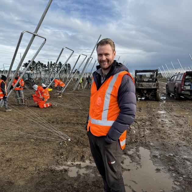 Orchard manager Matt Bentley of Ashburton oversees trellis installation prior to planting next...