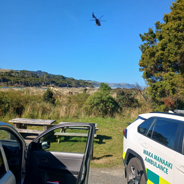 A helicopter flies over emergency services near Papatowai. Photo: Nick Brook
