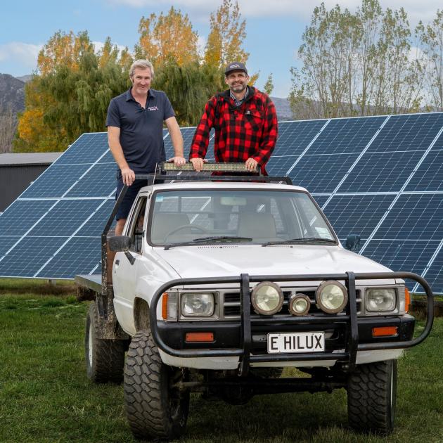 Cherry growers Mike Casey and Euan White with a converted electric Toyota Hilux ute on an orchard...