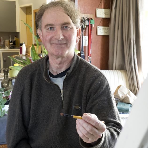 Evansdale artist Greg Abbott puts the finishing touches on his latest artwork from his left...