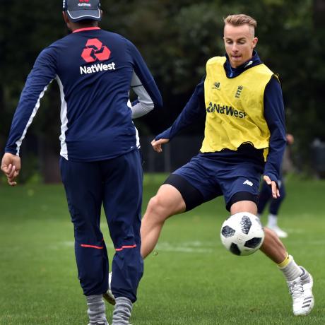 England seamer Tom Curran warms up for a training session with a game of football at the University Oval yesterday. Photo: Peter McIntosh