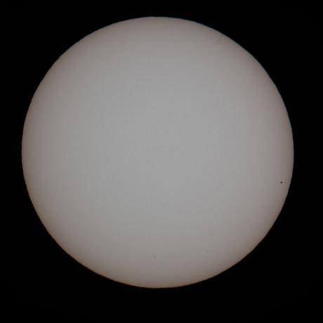 Mercury can be seen as a silhouette near the edge of the sun, about 6.30am yesterday. Photo: Ian Griffin