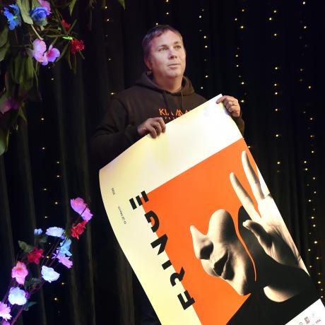 Dunedin Fringe Festival director Gareth McMillan rolls up a poster for the cancelled festival....