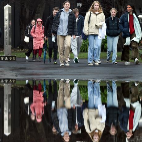 Students avoid a large puddle while walking by the Otago Museum Reserve yesterday. PHOTO: PETER...