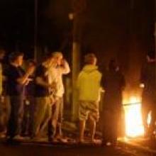 Students gather around a burning shopping trolley on Hyde St. Photo by Craig Baxter. Students gather around a burning shopping trolley on Hyde St. Photo by Craig Baxter.