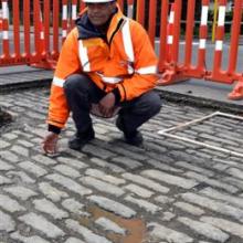 Dunedin City Council engineering project manager Janan Nirainjanan with a patch of cobblestones discovered on Duke St. PHOTO: PETER MCINTOSH