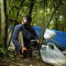 Jolyon White cooks at his bivvy in the Dunedin Town Belt, where he has been living for the past month. Photo by Gerard O'Brien.