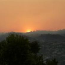 The sun peeks through the smoke over Signal Hill this morning. 