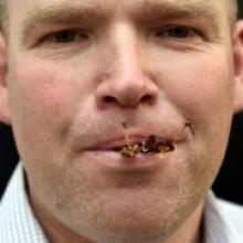 Otago Daily Times reporter Shawn McAvinue eats a locust in Dunedin yesterday. 