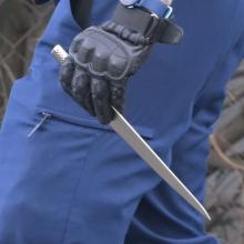 A police officer holds a knife confiscated from the man.