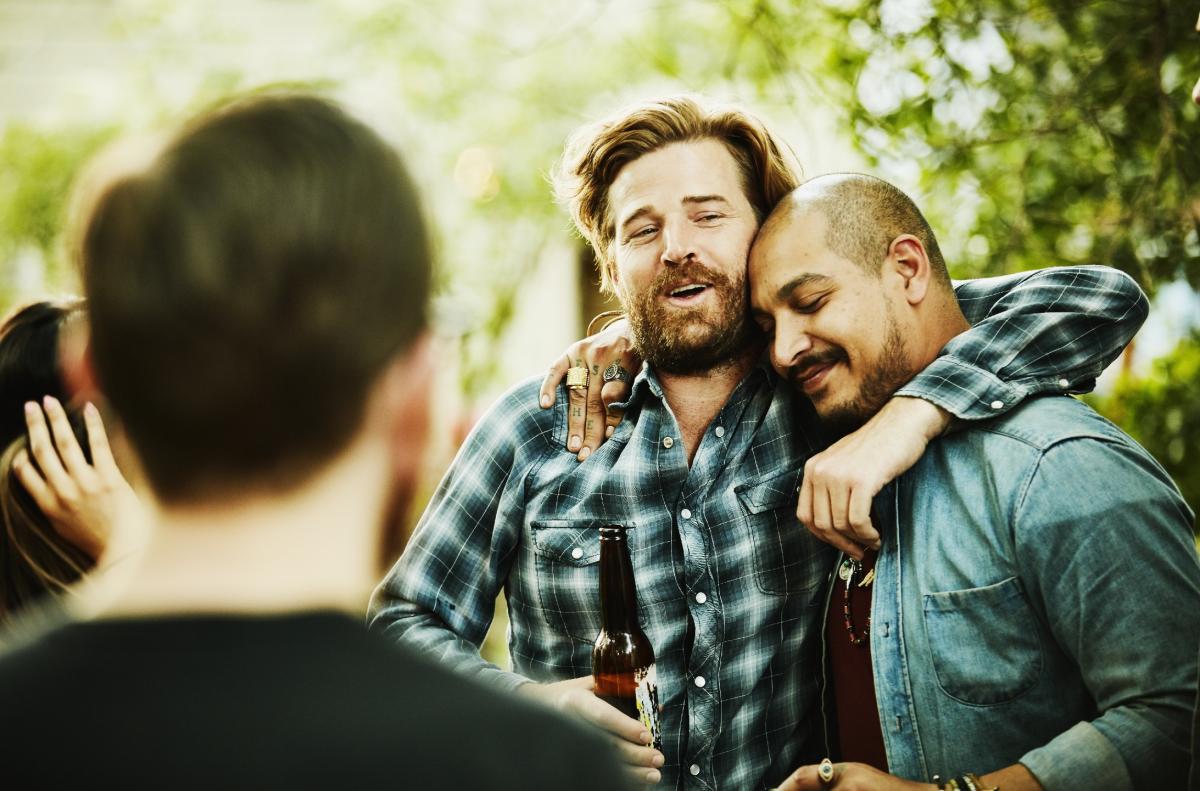 Embrace masculinity. Men pose with friend. Less likely
