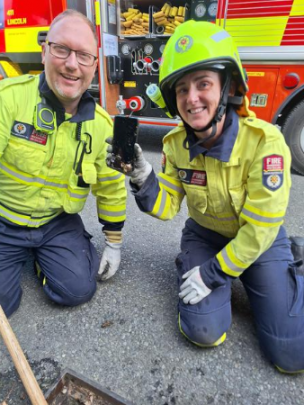 Lincoln firefighters Hayden Reed and Jayne Henare with the retrieved cellphone. PHOTO: BARRY CLARKE