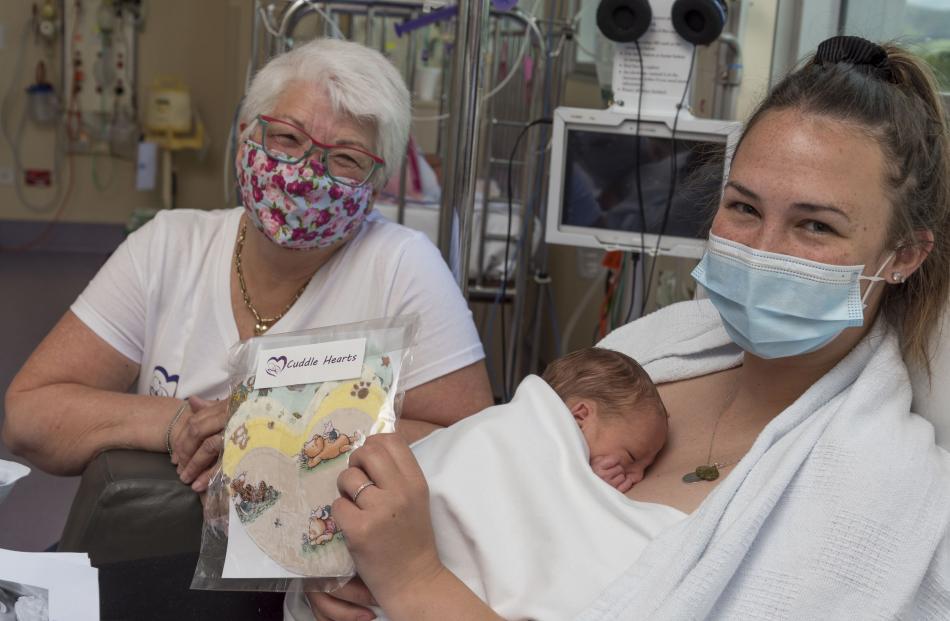 Lisa Paget gives a set of Cuddle Hearts to Nikita Christensen and baby Flynn at Christchurch...
