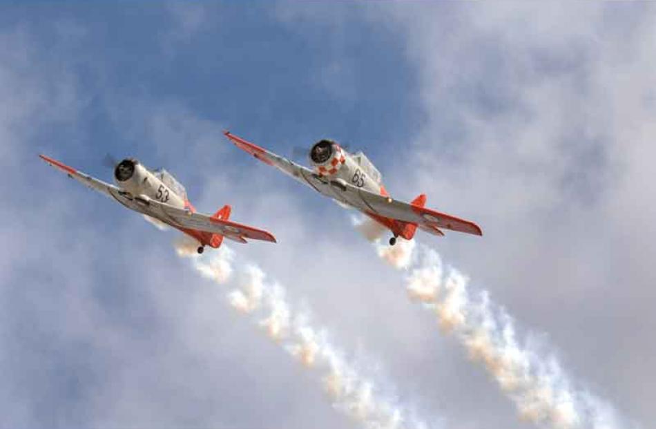 Two Harvard trainers trail smoke as they climb skyward. Photo by Stephen Jaquiery.