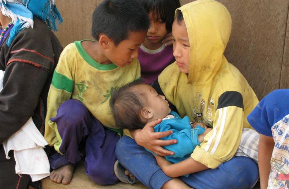 A group of Akha children cradle an even younger member of their tribe.