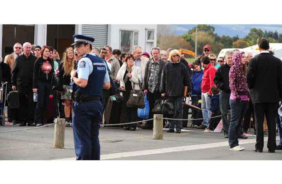 Evacuated passengeras and staff wait during a bomb scare at Dunedin International Airport