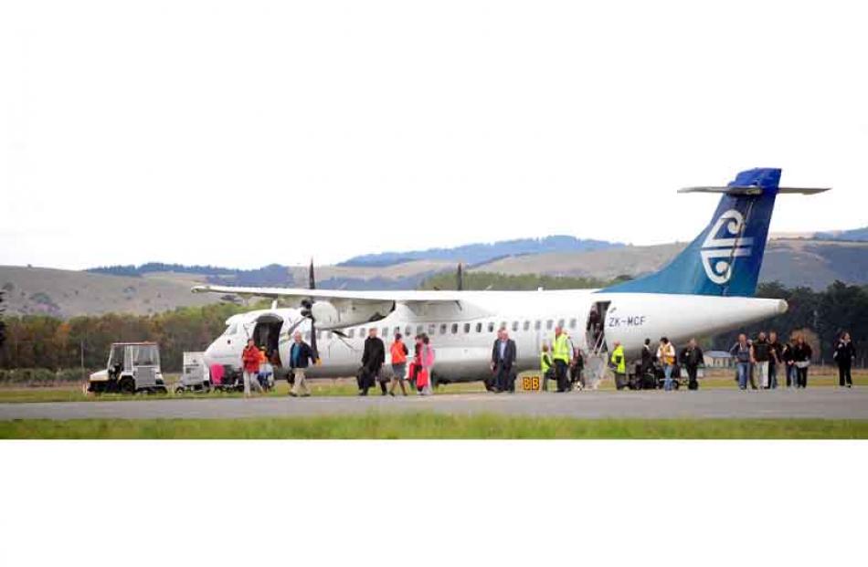Passengers unload from an Air NZ flight during a bomb scare at Dunedin International Airport