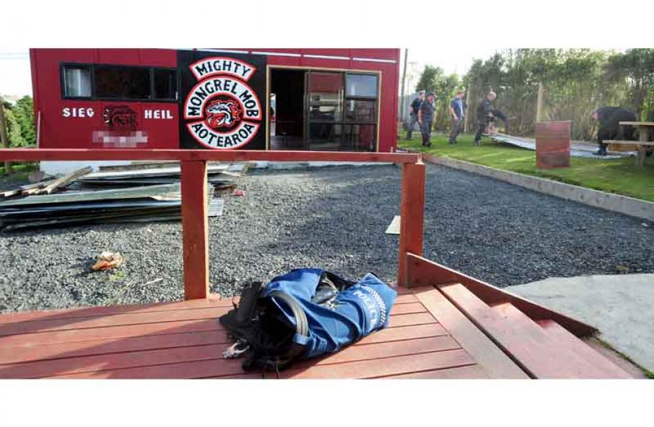 A police vest remains on the deck at the back of a house, as police work to remove a section of...
