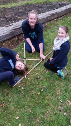 Leader Kimberley Smith helps Guides Hannah McArthur and Mikayla McDonnell start to build their...