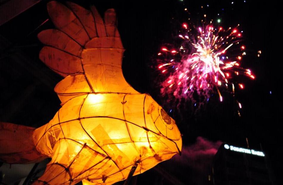 Fireworks from the roof of Forsyth Barr are seen behind a large lantern from the Dunedin...