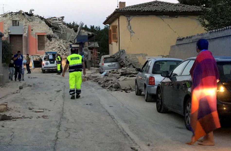 People stand along a road following a quake in Amatrice, central Italy, Photo: Reuters