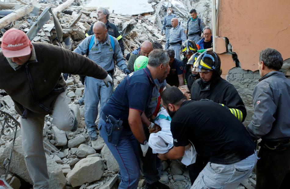 Rescuers carry a person on a stretcher following a quake in Amatrice, central Italy. Photo: Reuters