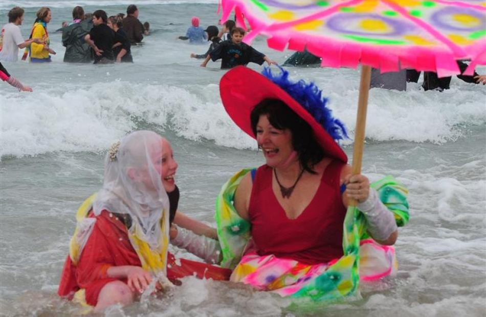 Amber Smith (11) and Linda McKie sit in the surf.