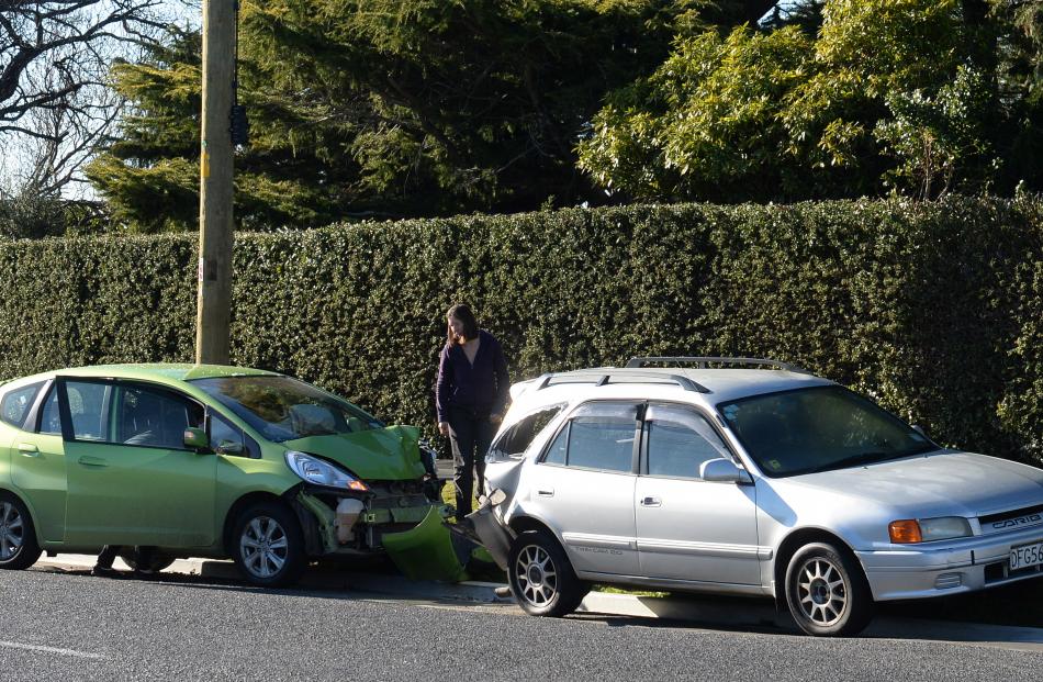 A woman, inspects the aftermath of a two-car crash in Dunedin. Photo by Linda Robertson.