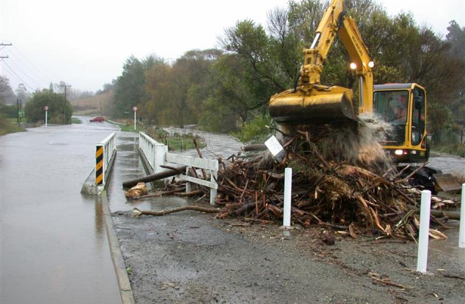 A digger clears debris which blocked the bridge on Chelmer St in Oamaru, flooding and closing the...