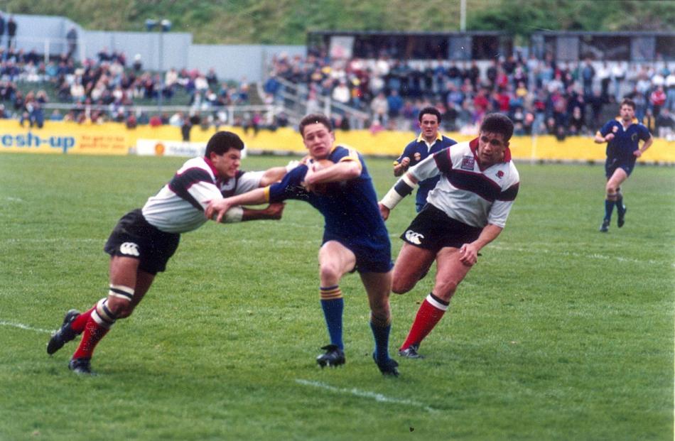 Otago winger Marc Ellis fends off a North Harbour player on the way to the tryline at Carisbrook...