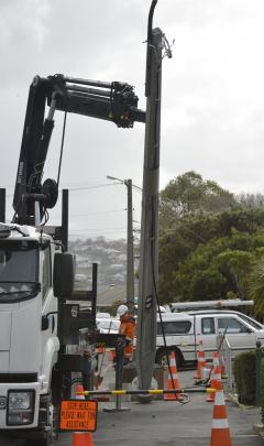 Contractors replace a power pole in Forbury Rd, which was felled by high winds last week. Photo:...
