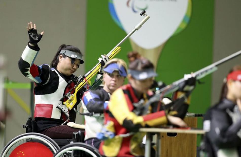 Zhang Cuiping (L) of China reacts in the Shooting Women's 50m Rifle 3P SH1 Final at the Olympic...
