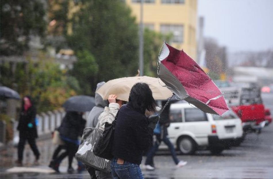 Students battle with the wind and rain as they cross Forth St, Dunedin, this week.