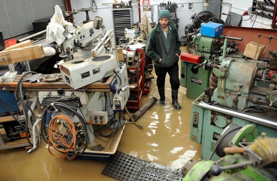 Jay MacLean surveys his still flooded engineering workshop at Henley yesterday. Photo by Stephen...