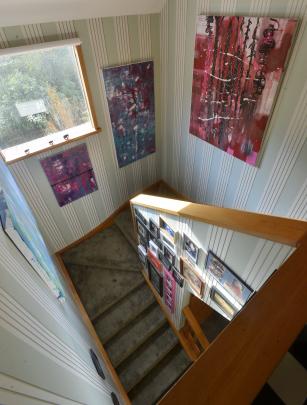 Ayla Hawkins’ abstract paintings hang in the stairwell.