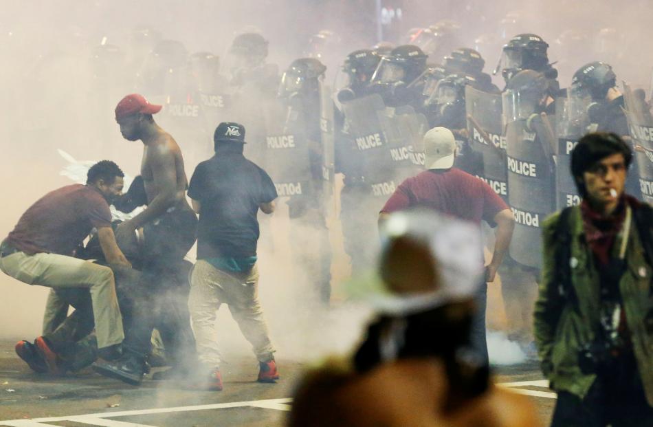 People maneuver amongst tear gas in uptown Charlotte, North Carolina, during a protest of the...