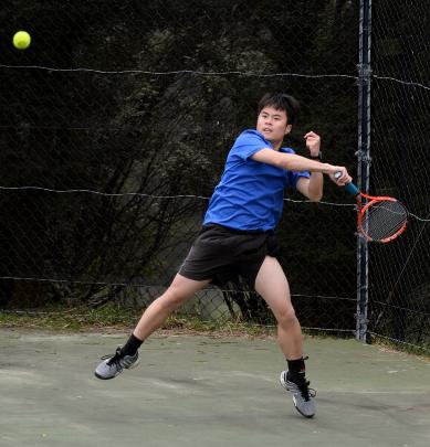 Paddy Ou, of the Balmacewen team, is well behind the baseline in returning a shot in a doubles...