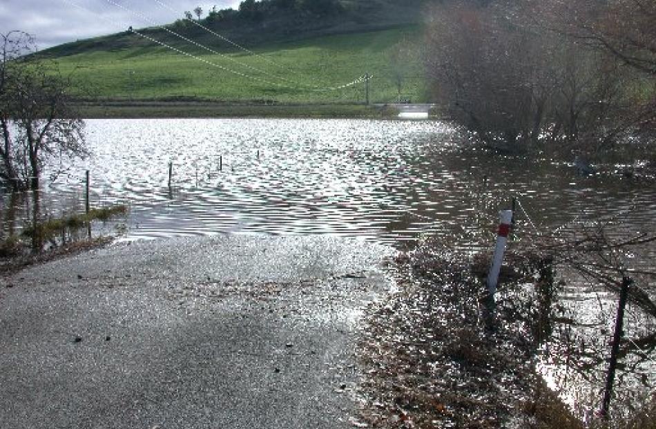 Floodwater still blocks Devil's Bridge Rd at its intersection with Oamaru Creek Rd, inland from...