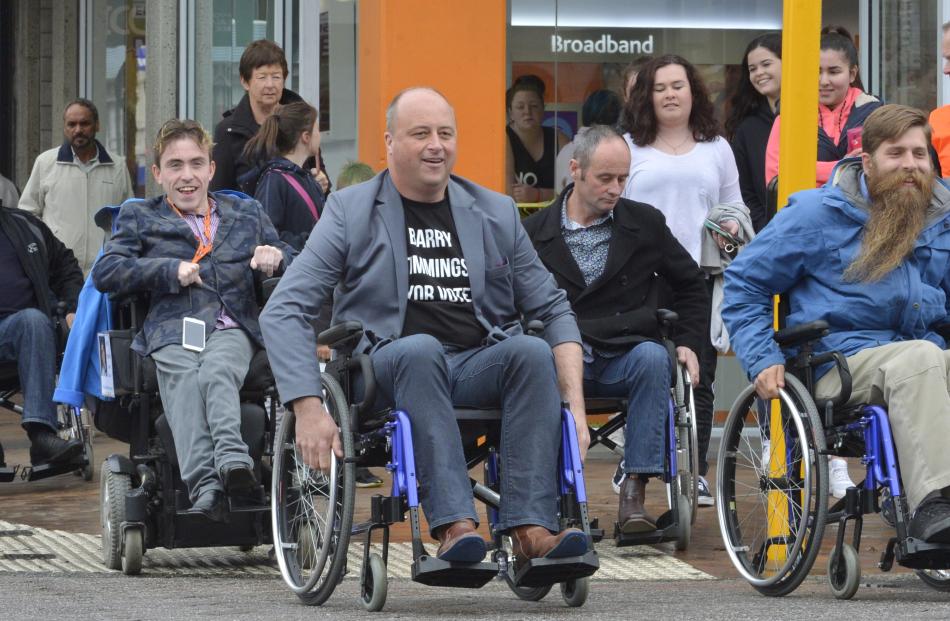 Mayoral candidate Cr Andrew Whiley, council candidate Joshua Perry, and mayoral candidates Barry Timmings, Jim O'Malley and Abe Gray make their way down George St in the candidates wheelchair challenge yesterday. Photos by Gerard O'Brien.