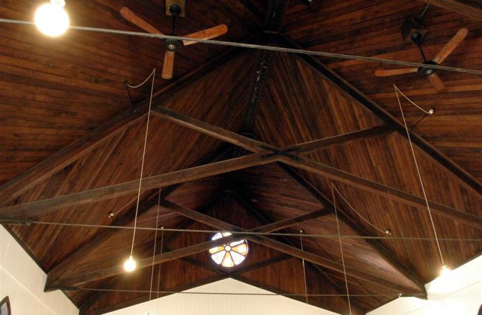 The tongue and groove church  ceiling with a small rose window at the gable.