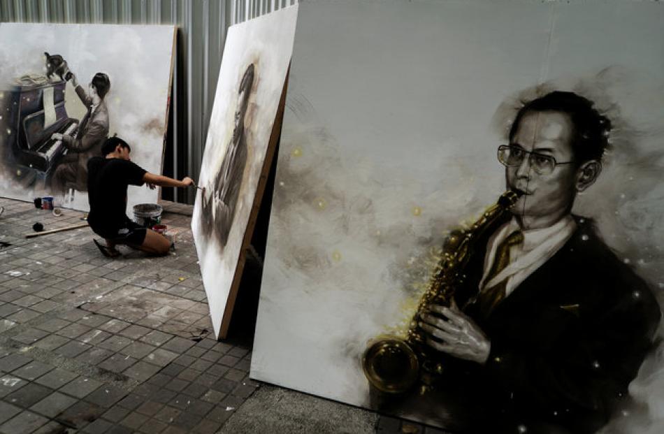 A Silpakorn University in Bangkok art student paints a portrait of the late King Bhumibol...