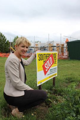 Real estate agent Rebecca Ireland crouches beside a recently sold section in Omakau. Photos by Jono Edwards.