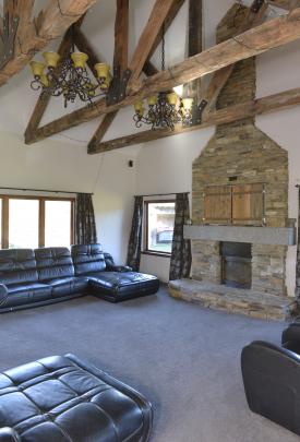 The trusses in the lounge were made from railway sleepers. The television is hidden behind wooden...